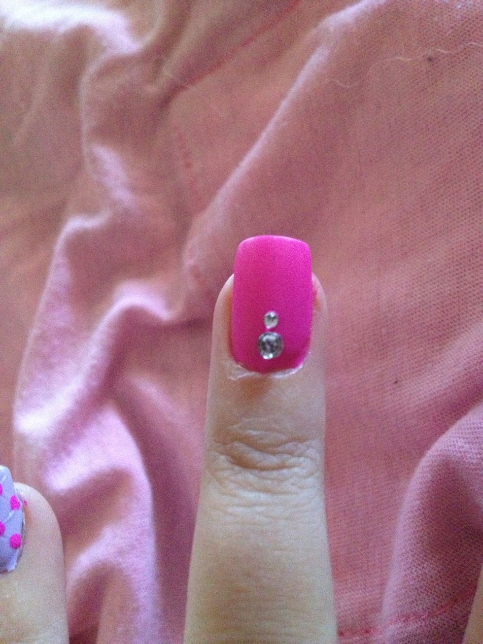 Step 9: Put a dab of matte top coat on pink nails and place two gems.