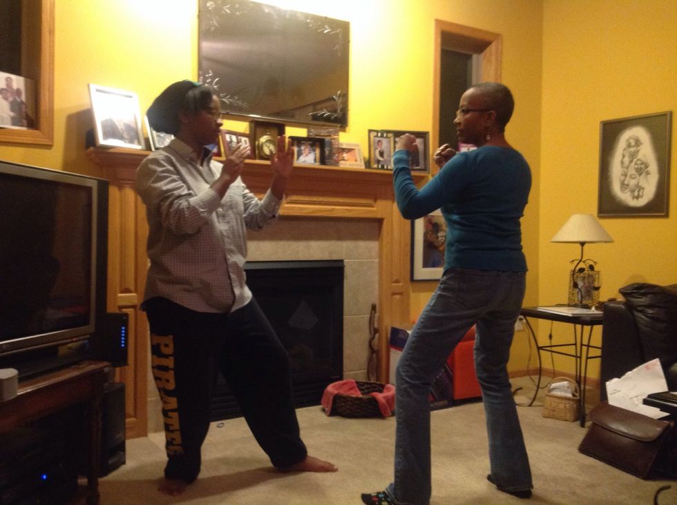 Step back into a fighting stance. The attacker should have their fists closed while the defender should have their hands open.