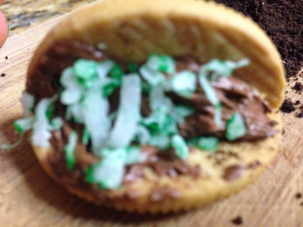 Step five: Grab the green coconut shavings and then put it on the taco shell