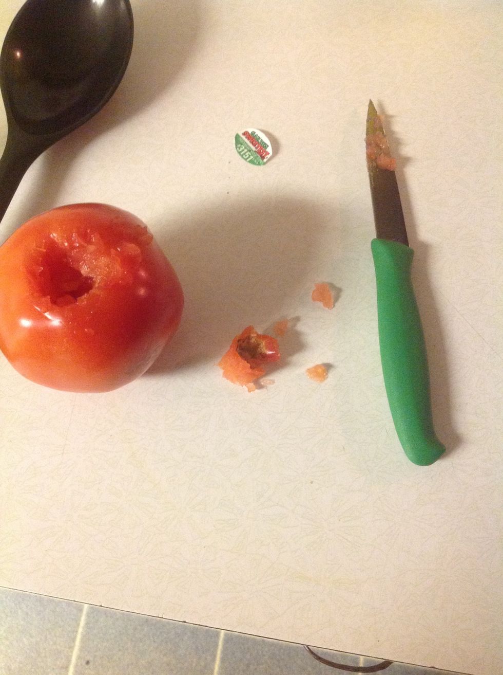 Step Four Core the tomato by using the teeth, pushing it in on the bottom, twist, and pull up. If you don't have a corer just use your knife, and cut out of the bottom.