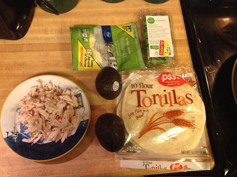 Step one: Gather all ingredients (shredded chicken, avocado, tortillas, cheese, and cilantro)