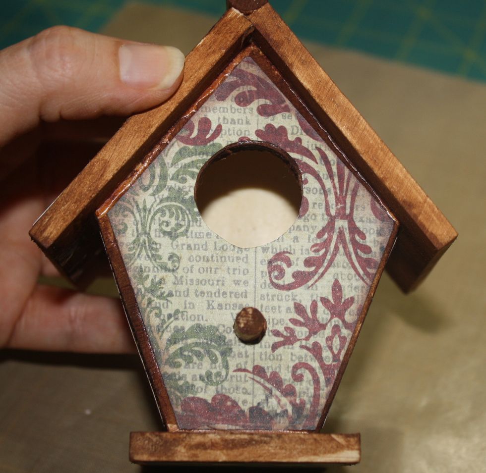 Step Six:  Cover the back and sides of the birdhouse.  Adhere paper with Mod Podge and allow time to dry.  Your birdhouse is now ready to be embellished.