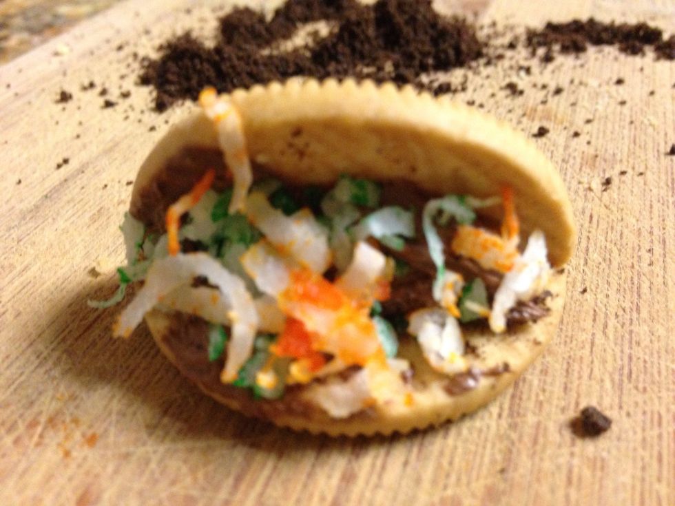 Step six: Grab the orange coconut shavings and put it on the taco shell