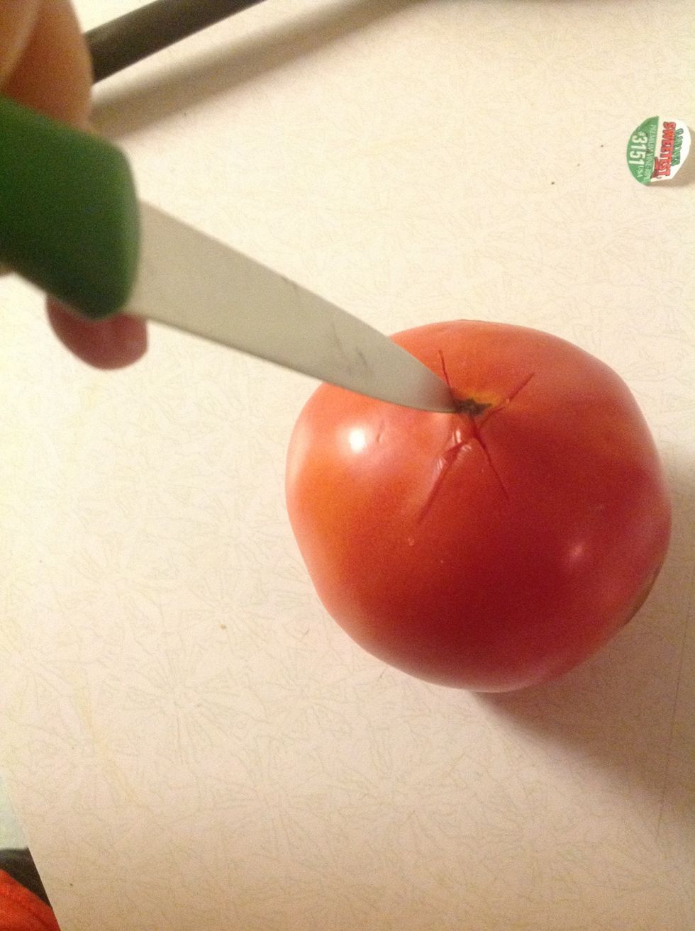 Step Three  Grab your knife and your tomato. Make an X on the top of the tomato. It doesn't have to be deep but enough to cut the skin. The purpose is to allow the skin to be easily peeled off.
