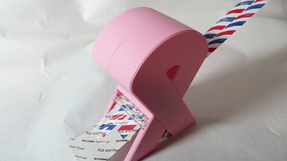 Step Three: Run your paper strips through the Xyron 1 1/2" Sticker Maker. I did two at once to maximize my adhesive use.