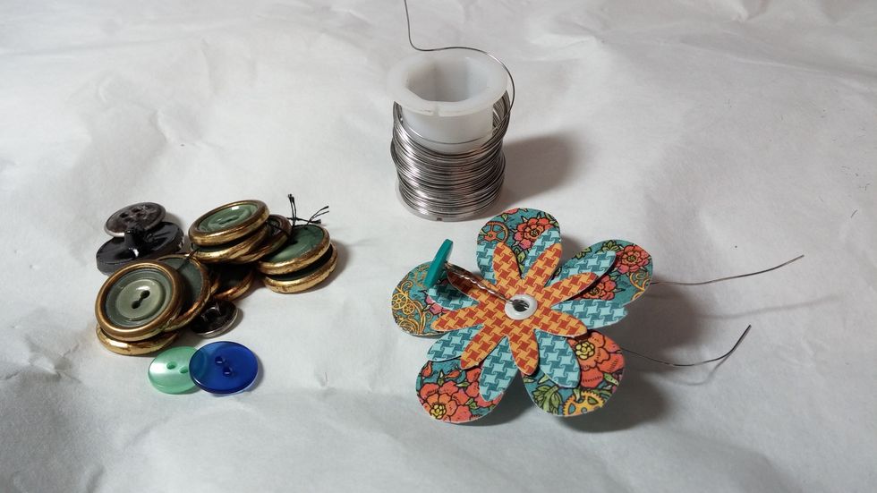 Step three: Thread your wire through the button and then through the eyelet hole.