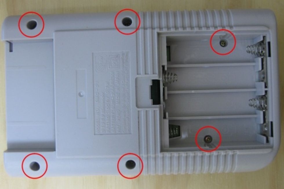 Step two is to remove the back cover of the DMG, depending when it was made, this is where you'll need the Triwing screwdriver. There are six screws, two of which are under the battery compartment.