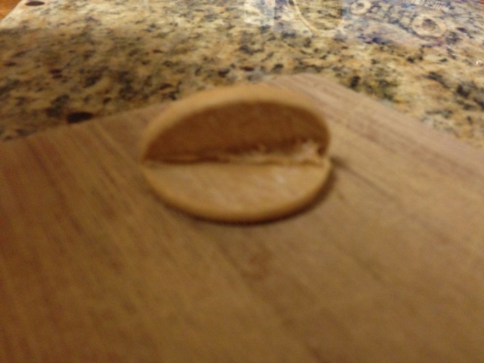 Step two: Put peanut butter on one edge of the Oreo and then stick the other half on to shape it like a taco shell
