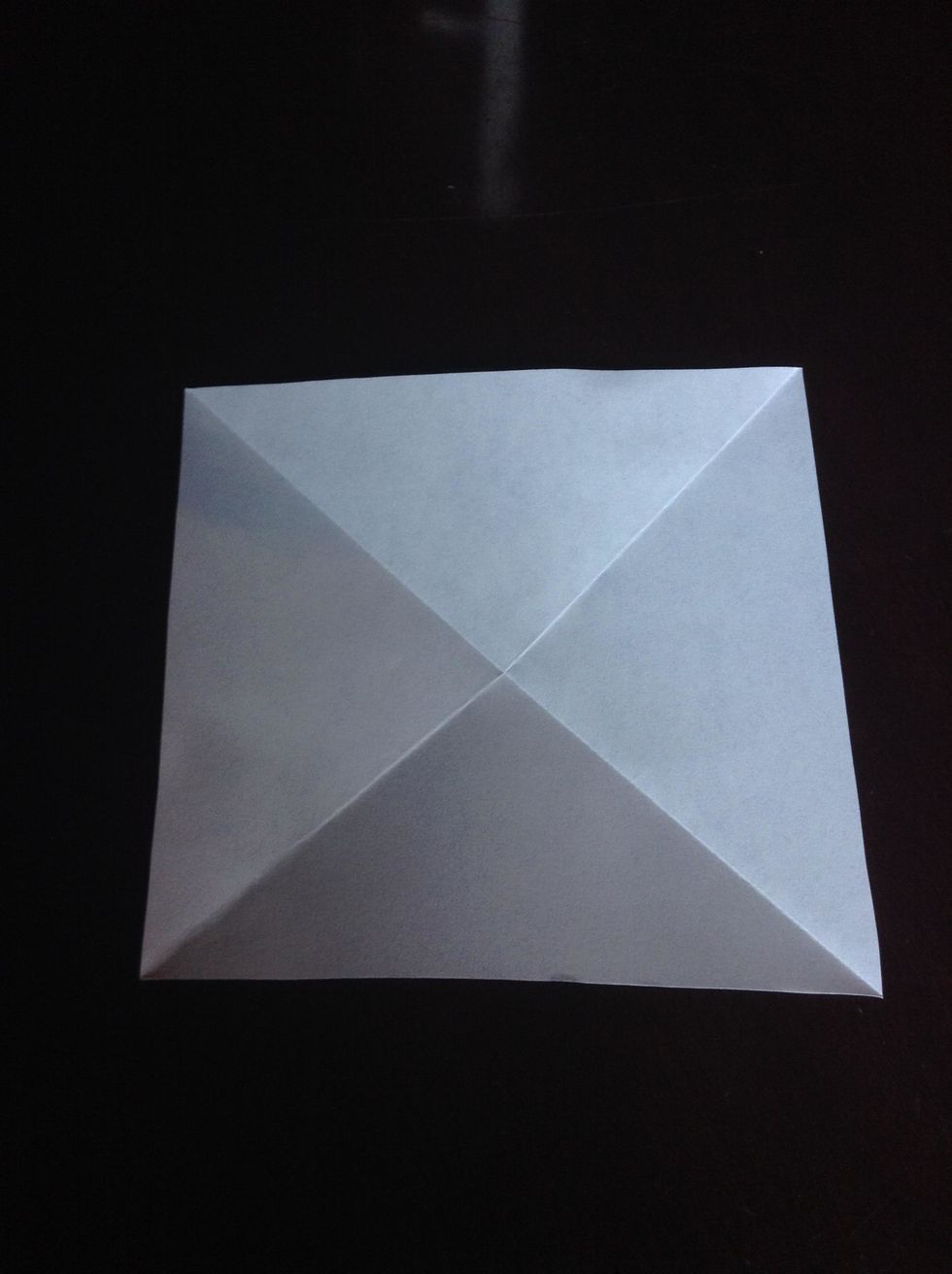 Step Two: Unfold your paper and fold the other corners just like in step one. Flip your paper over so when you lay it down, it is shaped like a pyramid. Your paper should look like this.