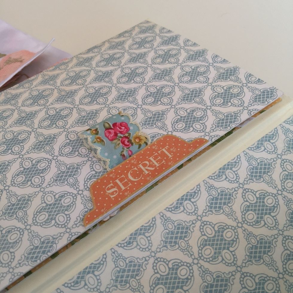 Stick a cardstock sticker and a piece of ribbon to pull and open the card.