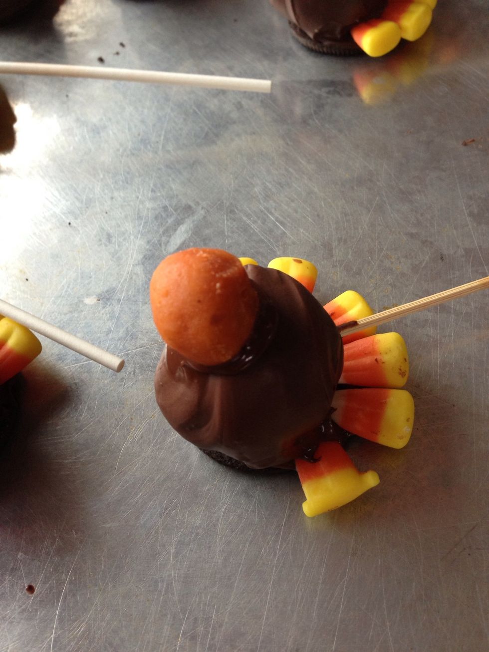 Stick a small ball as head quickly before chocolate sets.