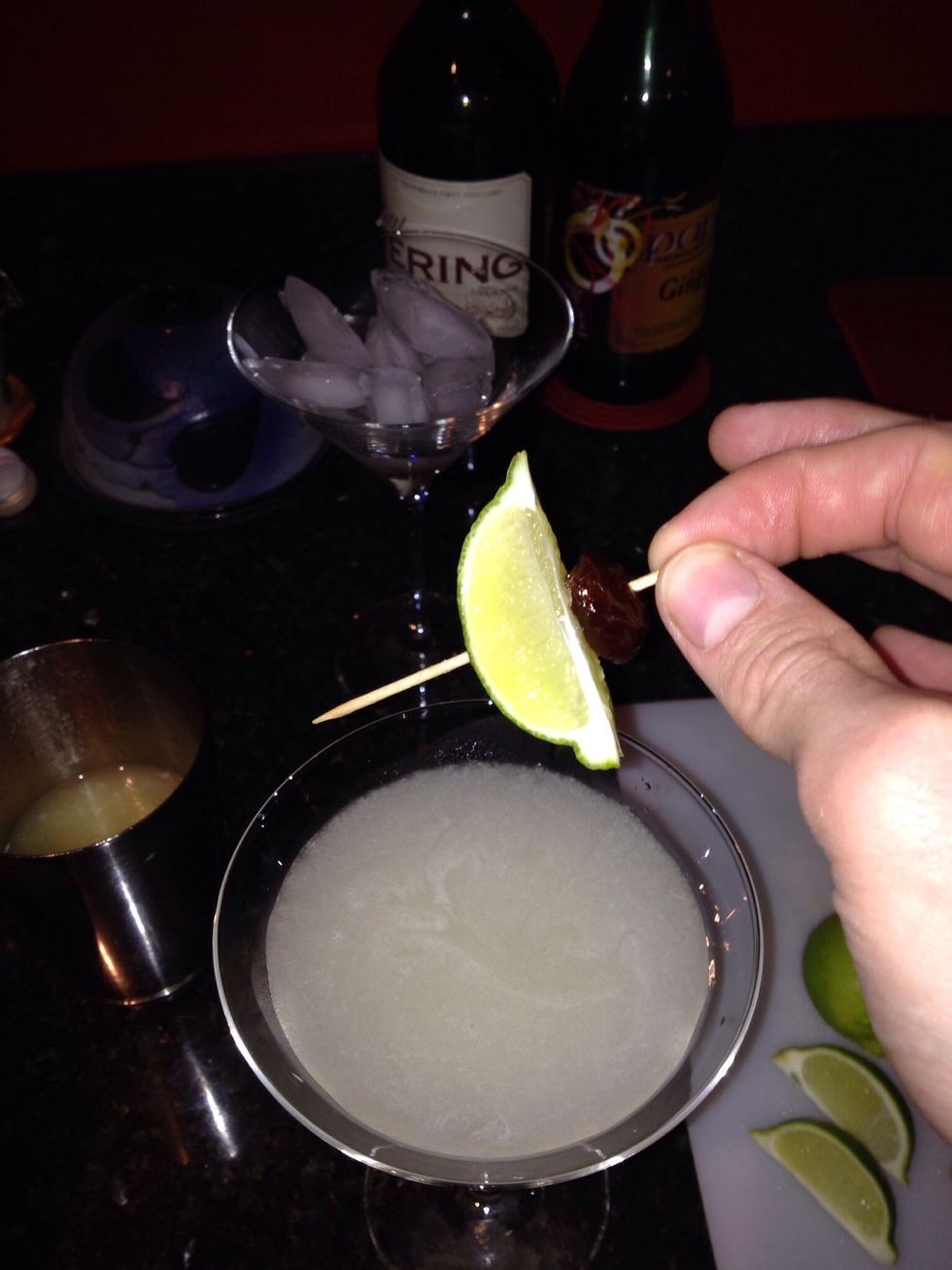 Stick a wee lime wedge on it with a cocktail stick and drop it in