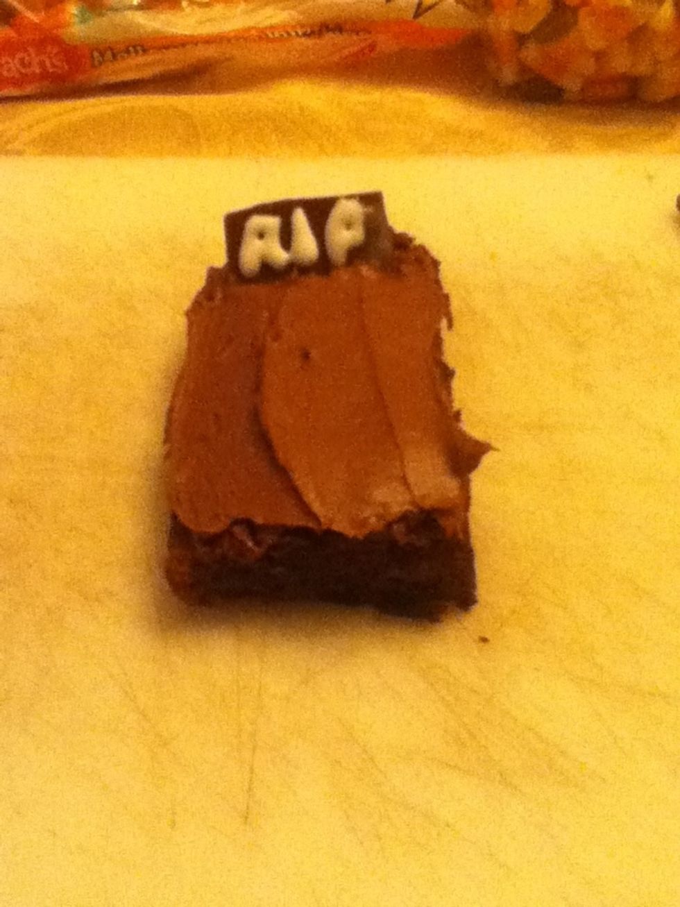 Stick bar of chocolate or "tombstone" standing up in icing.