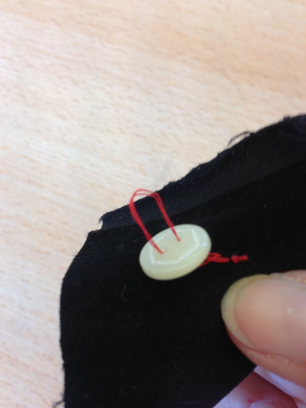 Stick ner genom det andra h\u00e5let och genom tyget till avigsidan. G\u00f6r s\u00e5 h\u00e4r ca 4 g\u00e5nger. Har du fler h\u00e5l i din knapp? G\u00f6r likadant.