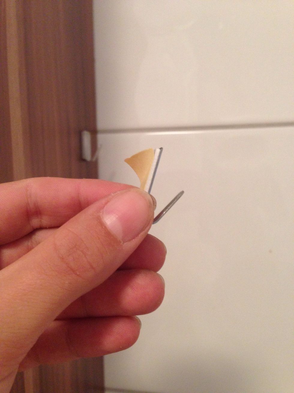 Stick the hooks on each side of the wall where you want your holder to be