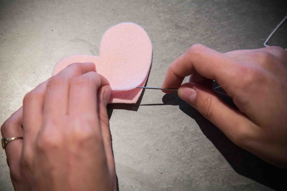 Stick the needle through one of the felt hearts, about 5mm from the edge.