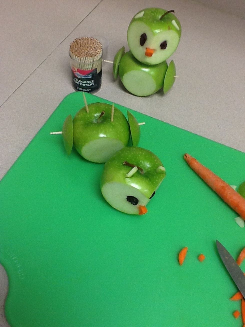 Stick the raisins into the apple owls eyes, and put the carrot four into the nose hole, place tooth picks into the apple head