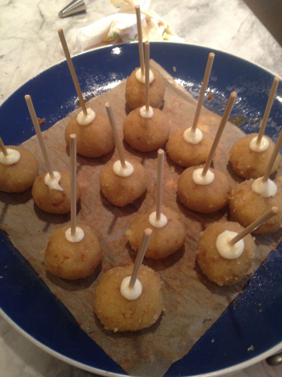 Stick tip of sticks in melted chocolate, then insert them into the balls of cake