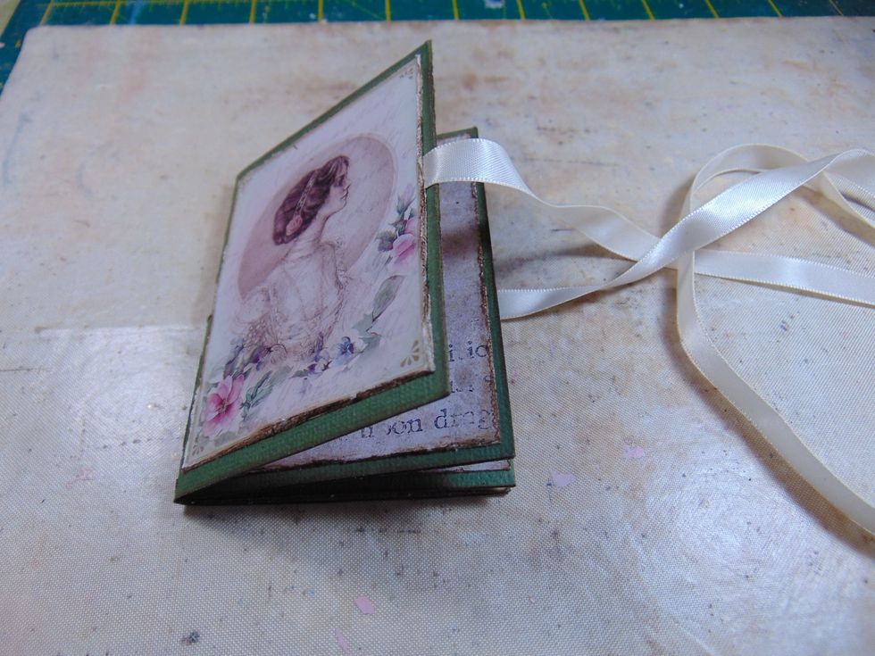 Stick your album covers on over the top of the ribbon. Tie ribbon in a bow to shut album and trim the excess off.