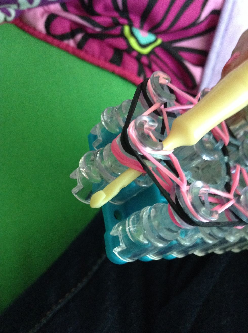 Stick your hook under all the rubber bands on the very first peg we started on at the beginning