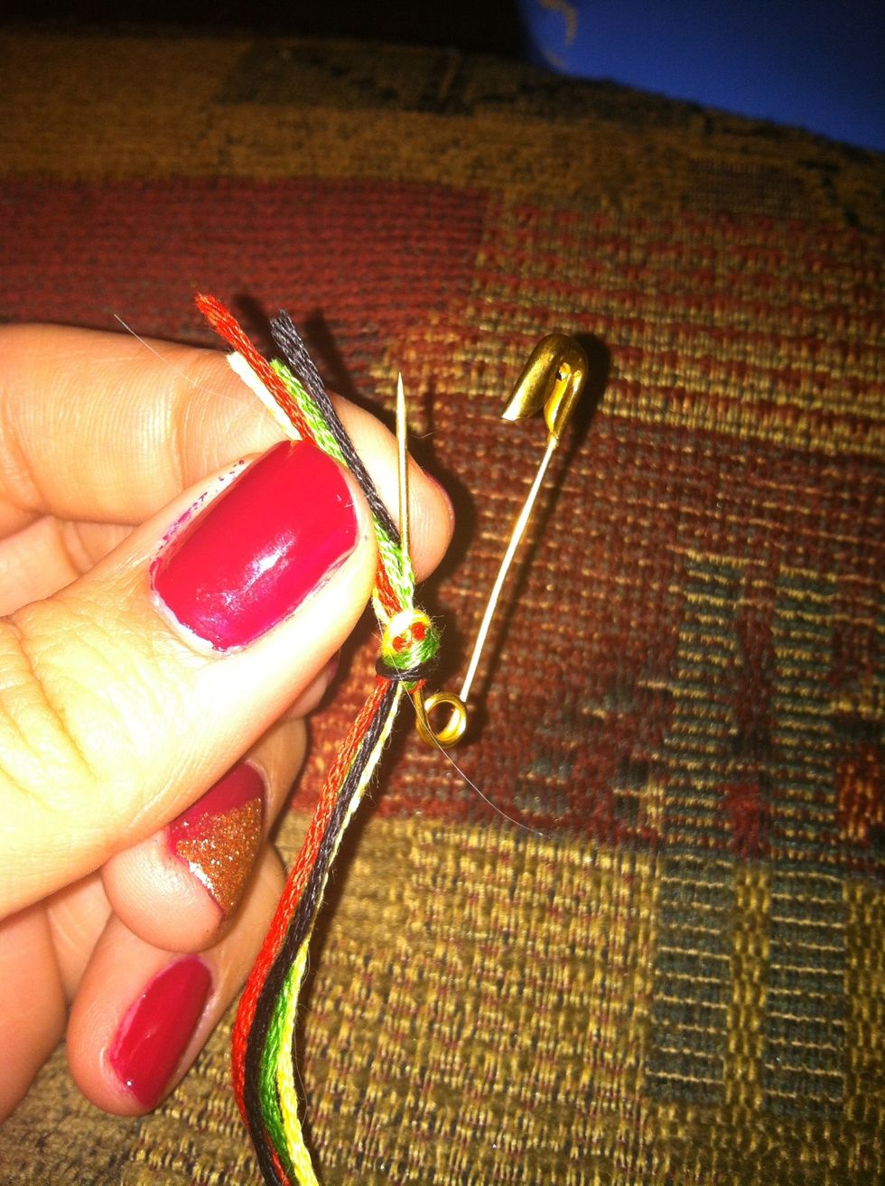 Stick your safety pin through the knot. Then, pin it to a nearby surface. Whatever you pin it to will serve as your anchor, so use something you can yank on (i.e. a pillow, pant leg, blanket).