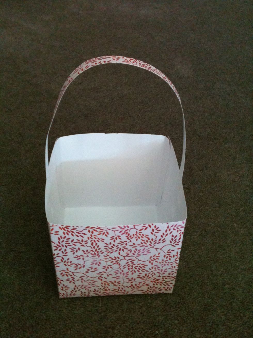 Sticky Tape the strip of paper to the inside of the basket to make the handle