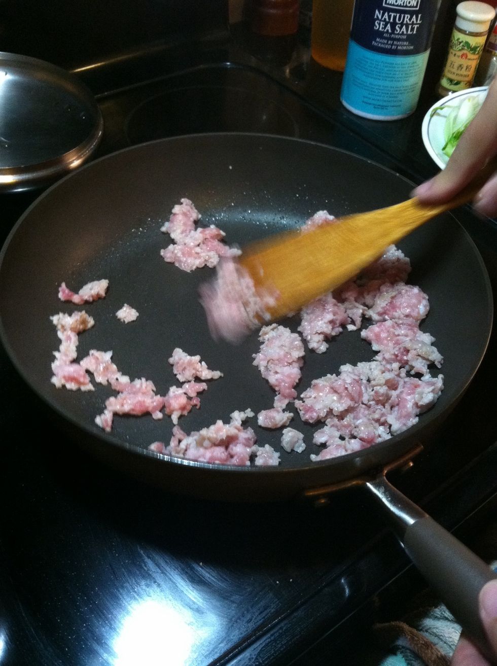 Stir fry pork over med heat. If using lean pork, add a little vegetable oil. Use a wooden spoon to smash the meat into smaller pieces. Add salt to taste. Cook until slightly browned and dry.