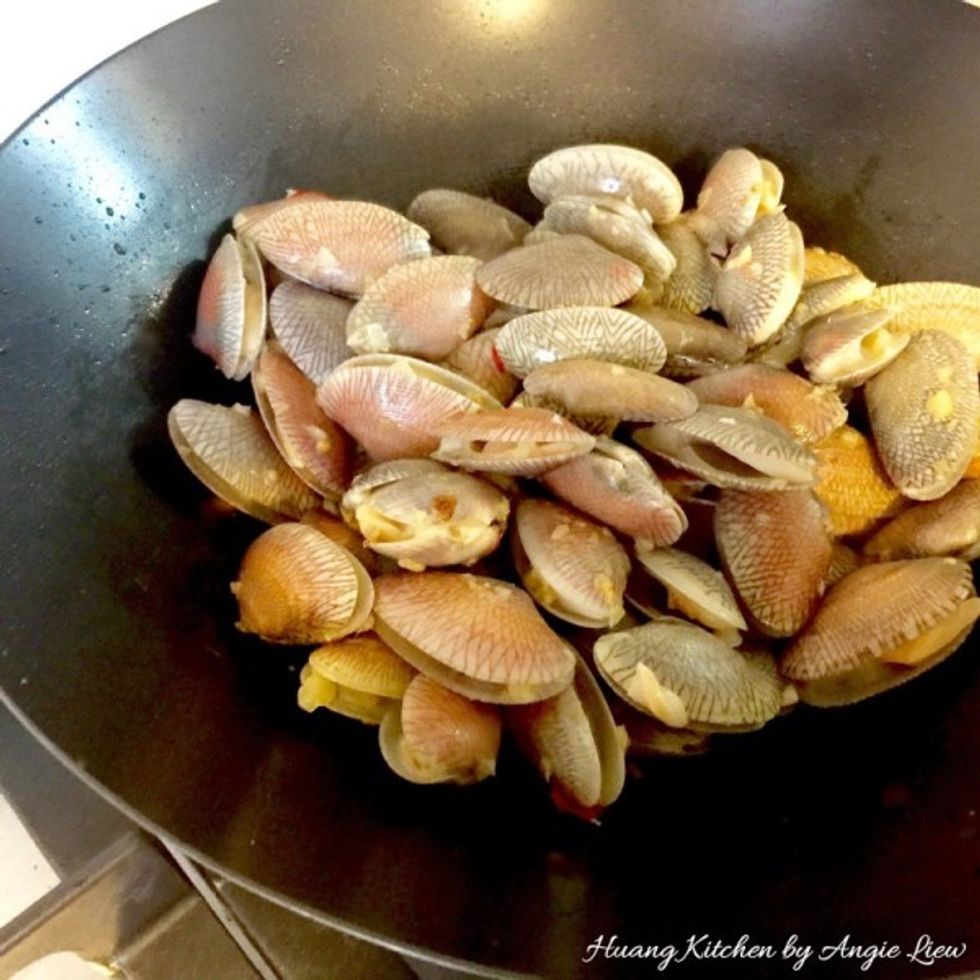 Stir fry until the shells of the clams turn orange in colour. Pick out the clams that don't open and discard them.