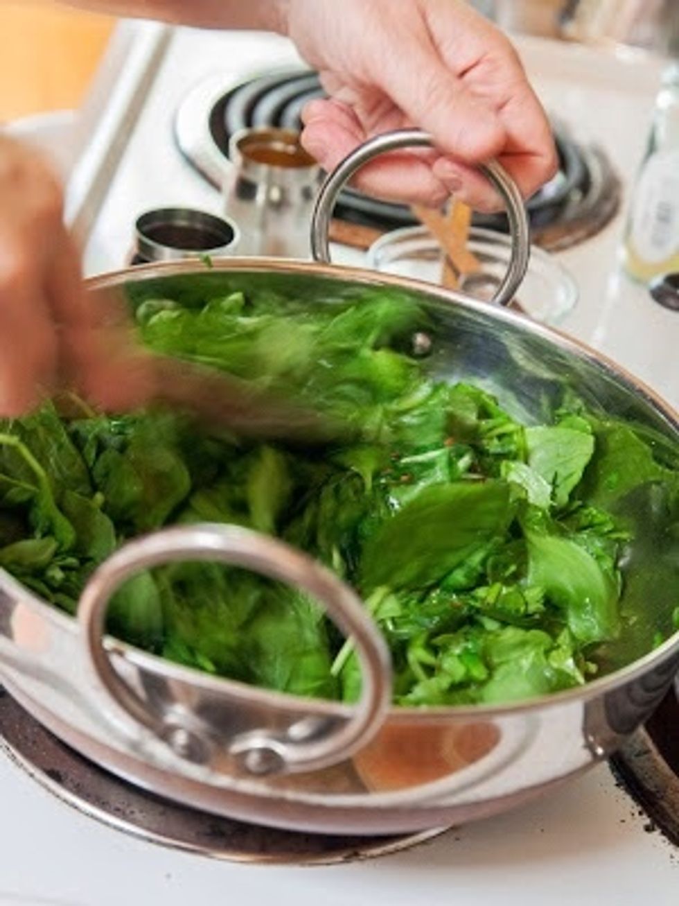 Stir them around. Put a lid on the pan and turn the heat down a bit until the greens are cooked.
