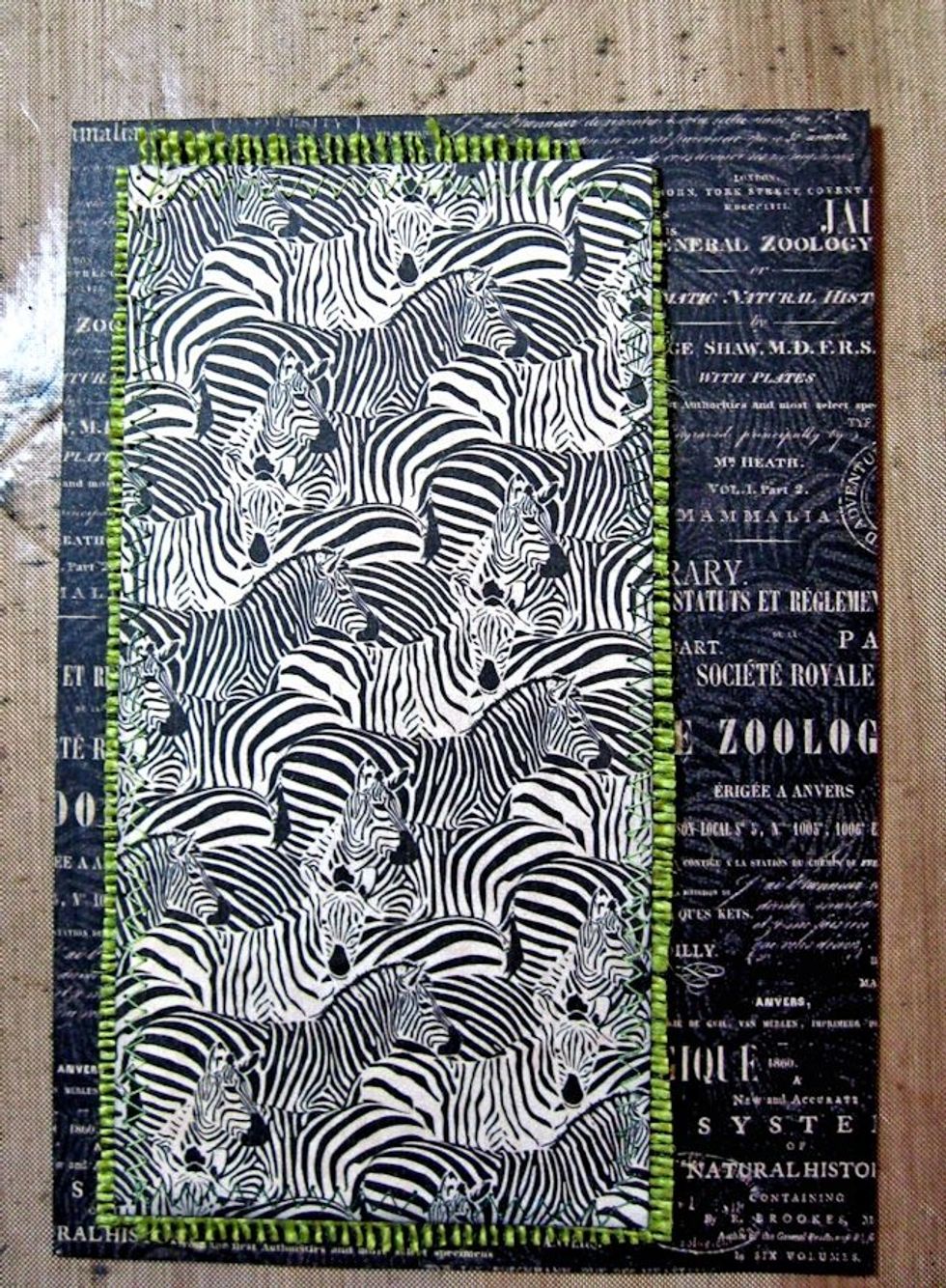 Stitch a 3" wide x 4 5?8" tall panel of Natural Habitat Zebra pattern onto green burlap. Glue in place as shown.