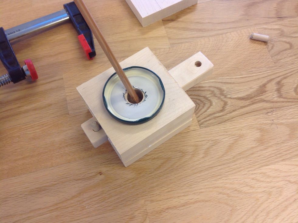 Stoppa i pinnen i mitten och m\u00e4rk ut var h\u00e5let ska borras. Observera att stopp i \u00e4ndarna p\u00e5 den l\u00e5nga biten fixas f\u00f6rst. Fundera sj\u00e4lv med hj\u00e4lp av bilden hur man g\u00f6r det.