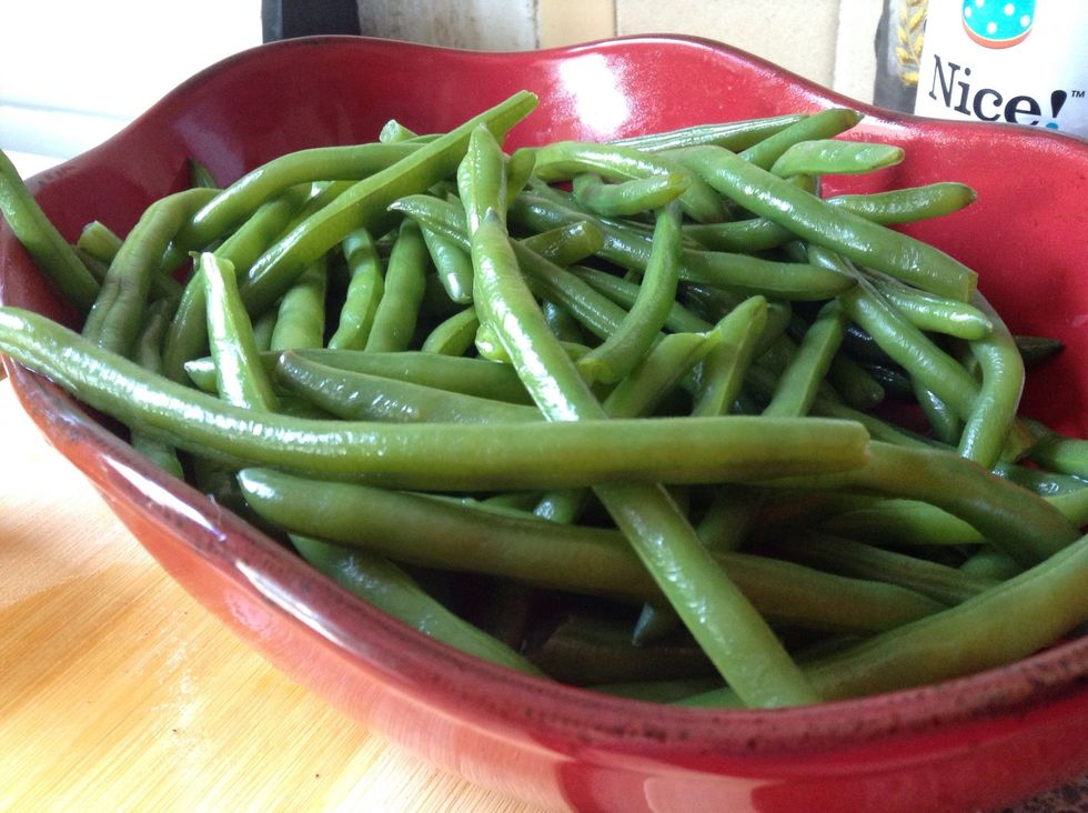Strain green beans and place in serving bowl