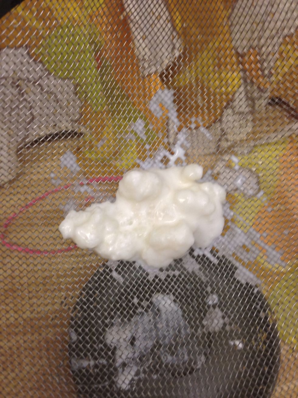 Strain kefir with fine metal mesh.