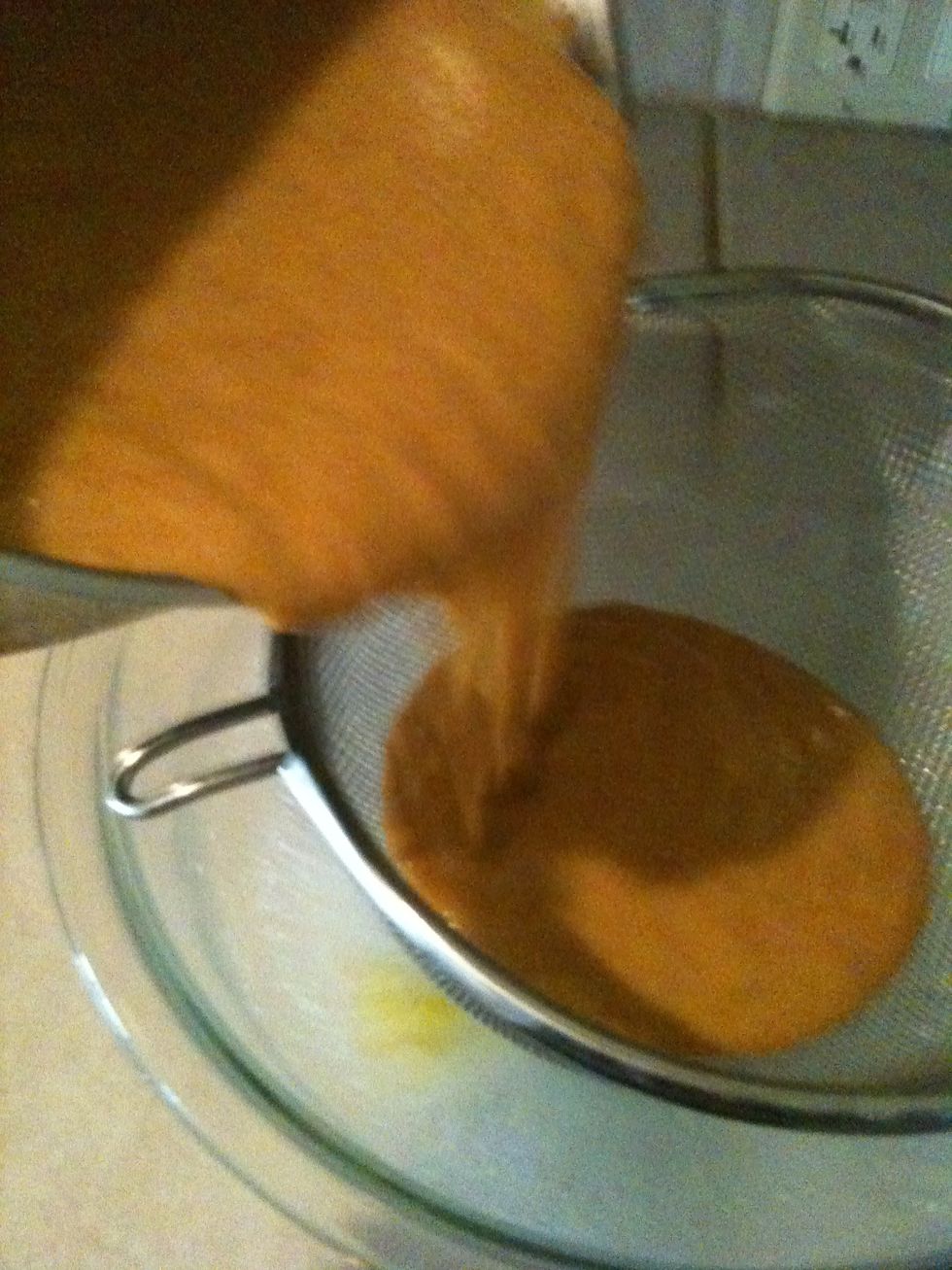 Strain mixture through fine-mesh strainer set over medium bowl, using back of ladle or spatula to press solids through strainer