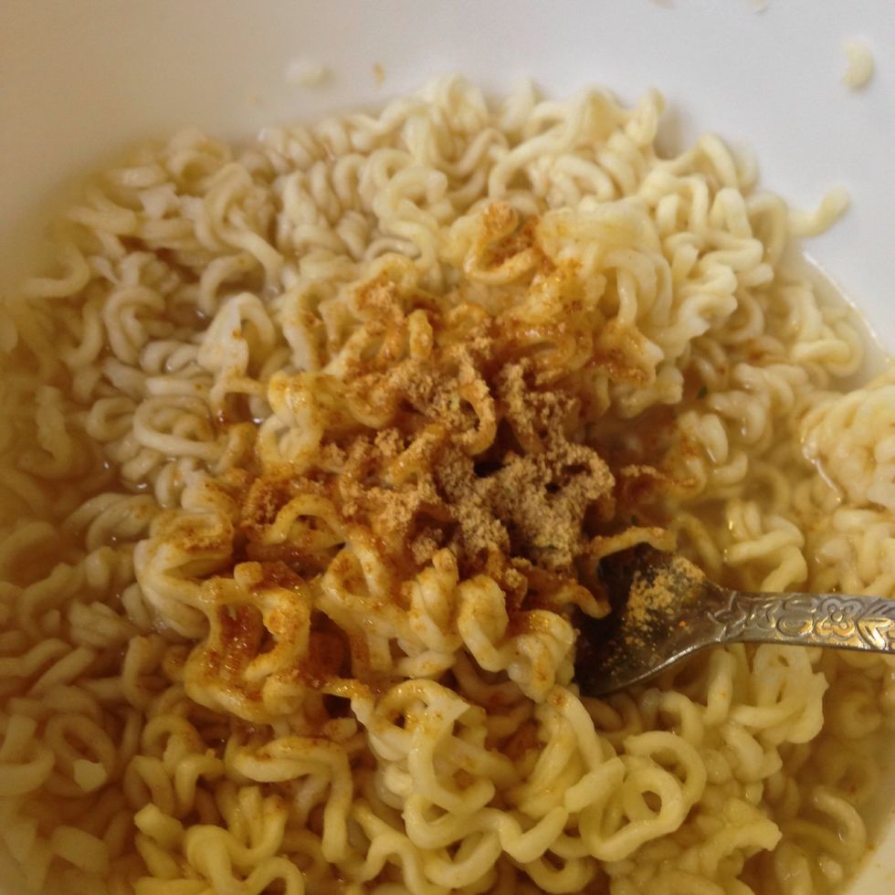 Strain your noodles leaving some water. Add only one package of seasoning that came with your noodles. Mix thoroughly .