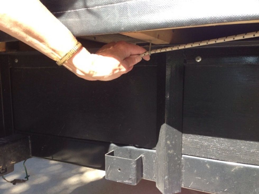 Stretch the bungee cord at bottom of cover to fit under each corner and under each hook along all four sides of the float to hold firmly in place.