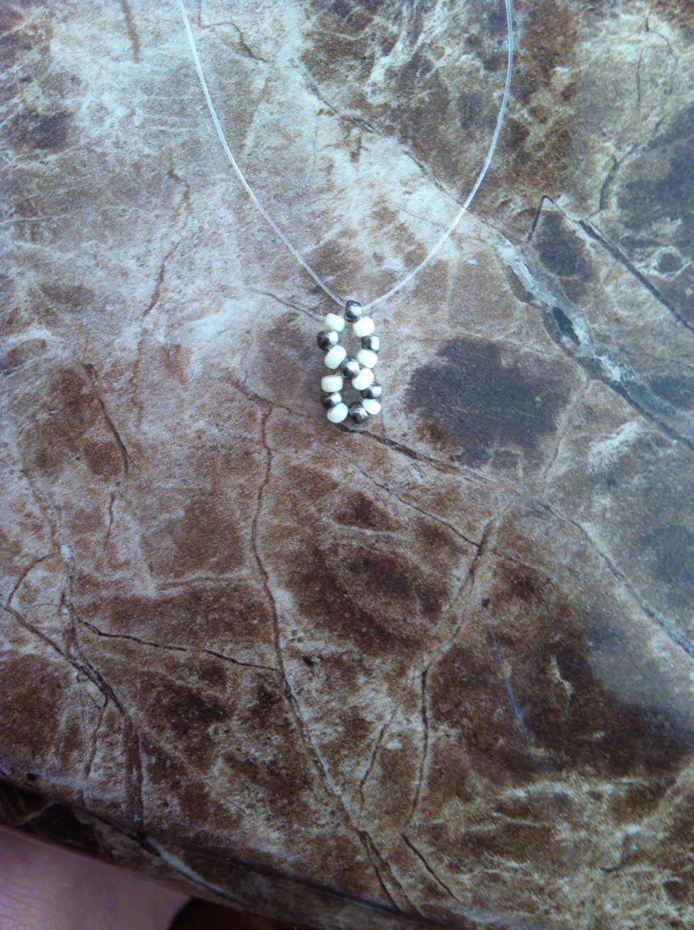 String a silver bead on one end, cross through it with the other cord and slide it down