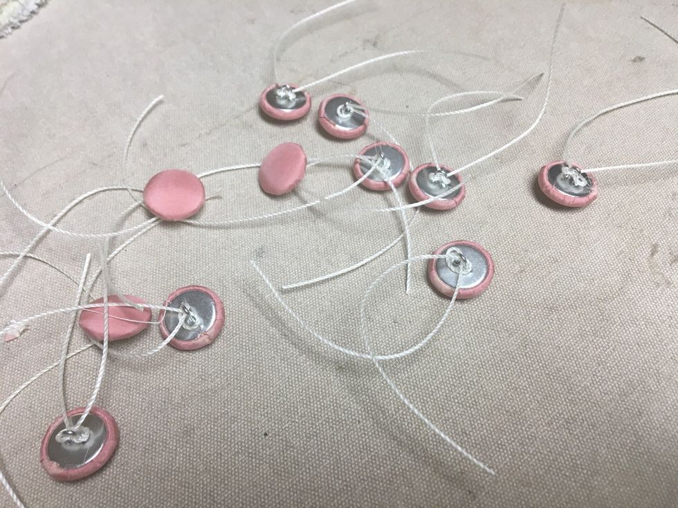 String all the buttons with tufting twine or dental floss as shown.  I used pink on one side and gray on the reverse.  So I had 10 pink and 10 gray for each chair.