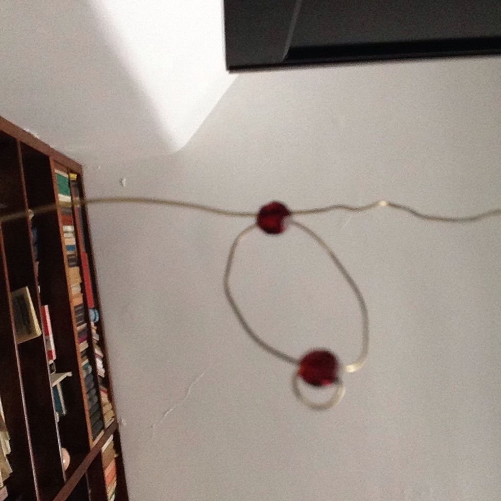 String another black/brown bead on one side of the wire and repeat the same steps you used for the first beed.