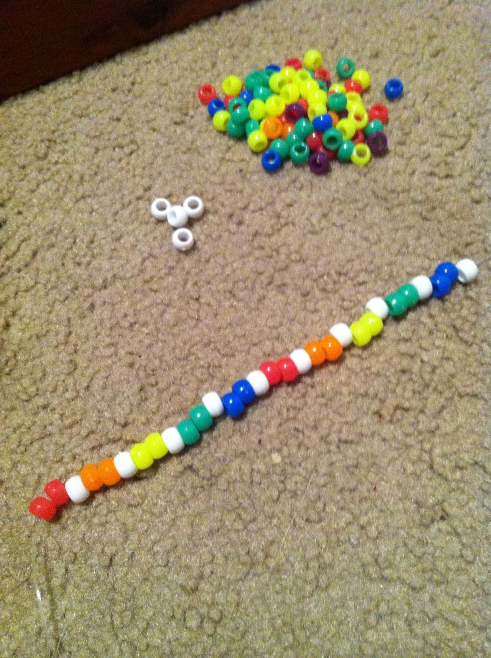 String on 2 beads then a white bead. I chose to go with a rainbow scheme. Must be an even number!