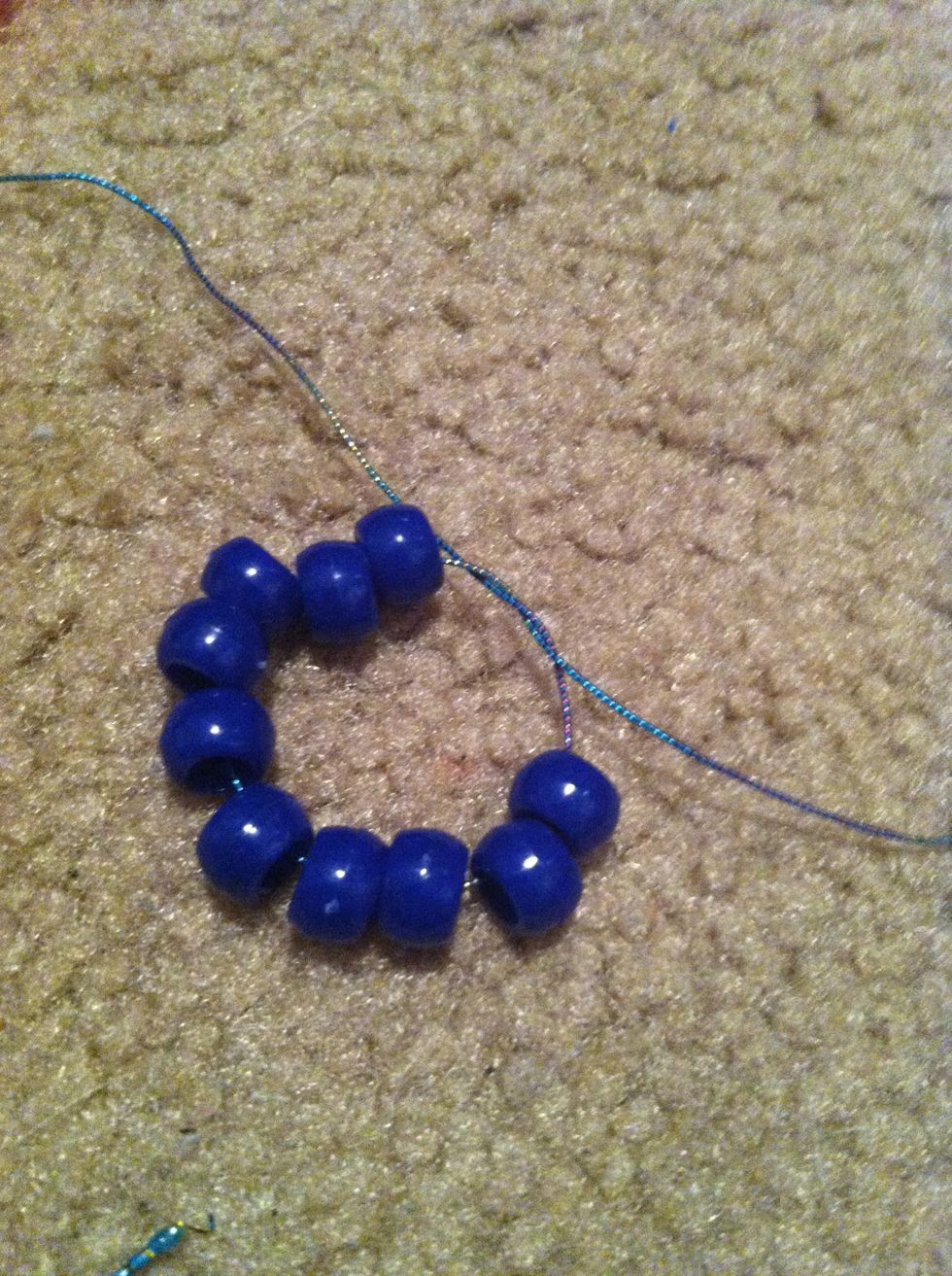 String the 10 beads onto the string and tie tightly twice leaving 2 or 3 inches on one side.