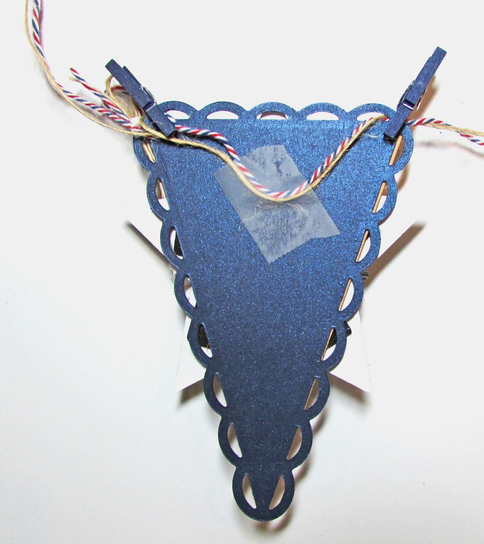 String the pennants together with twine. Use tape to secure twine to the back of each pennant. Glue mini clothes pins to each pennant corner.