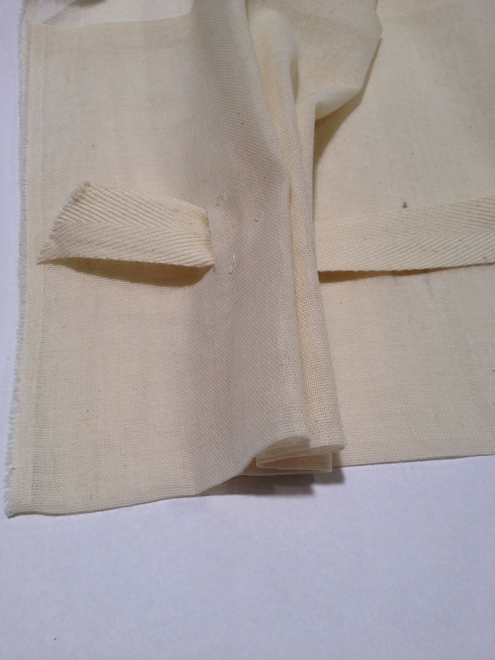 String the twill tape through the buttonholes.
