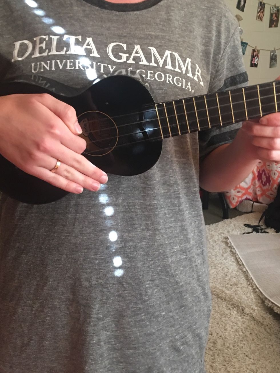 Strumming is a skill that becomes easier over time. Practice strumming with your pointer finger and start at the top string and strum down towards the ground.