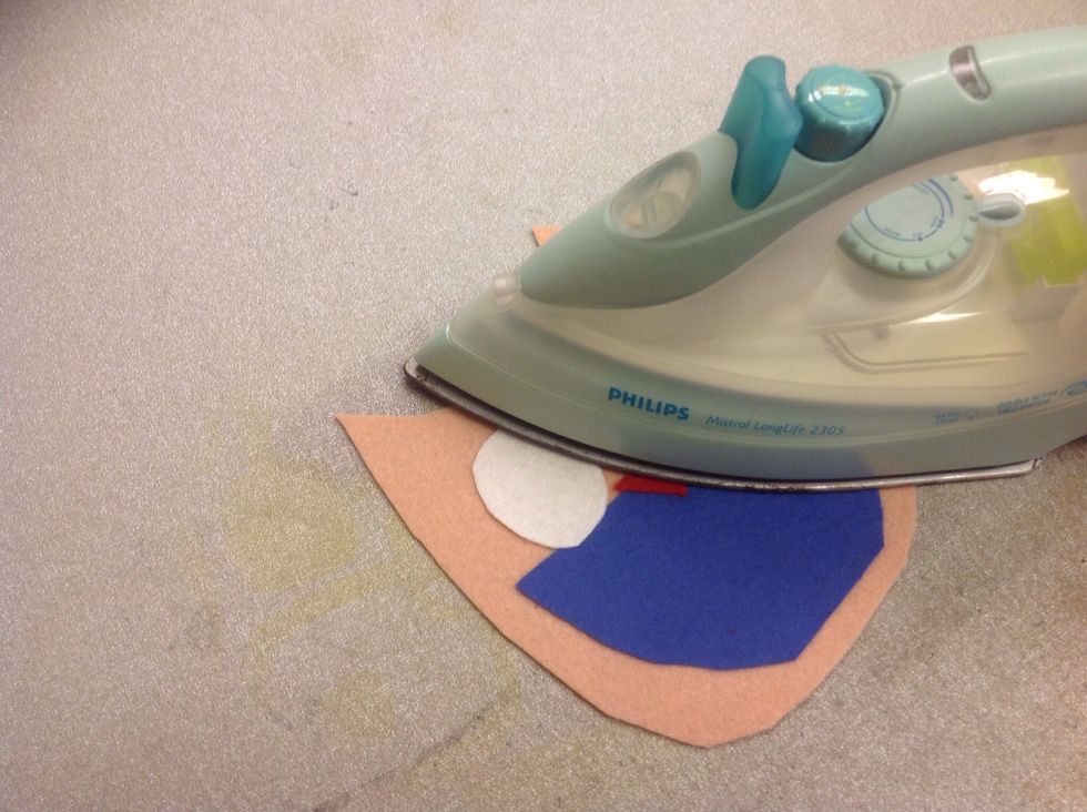 Stryk fast alla detaljer p\u00e5 framsidan av filtisen. Du ska nu brodera detaljerna som du inte strykit fast och brodera fast alla detaljer.