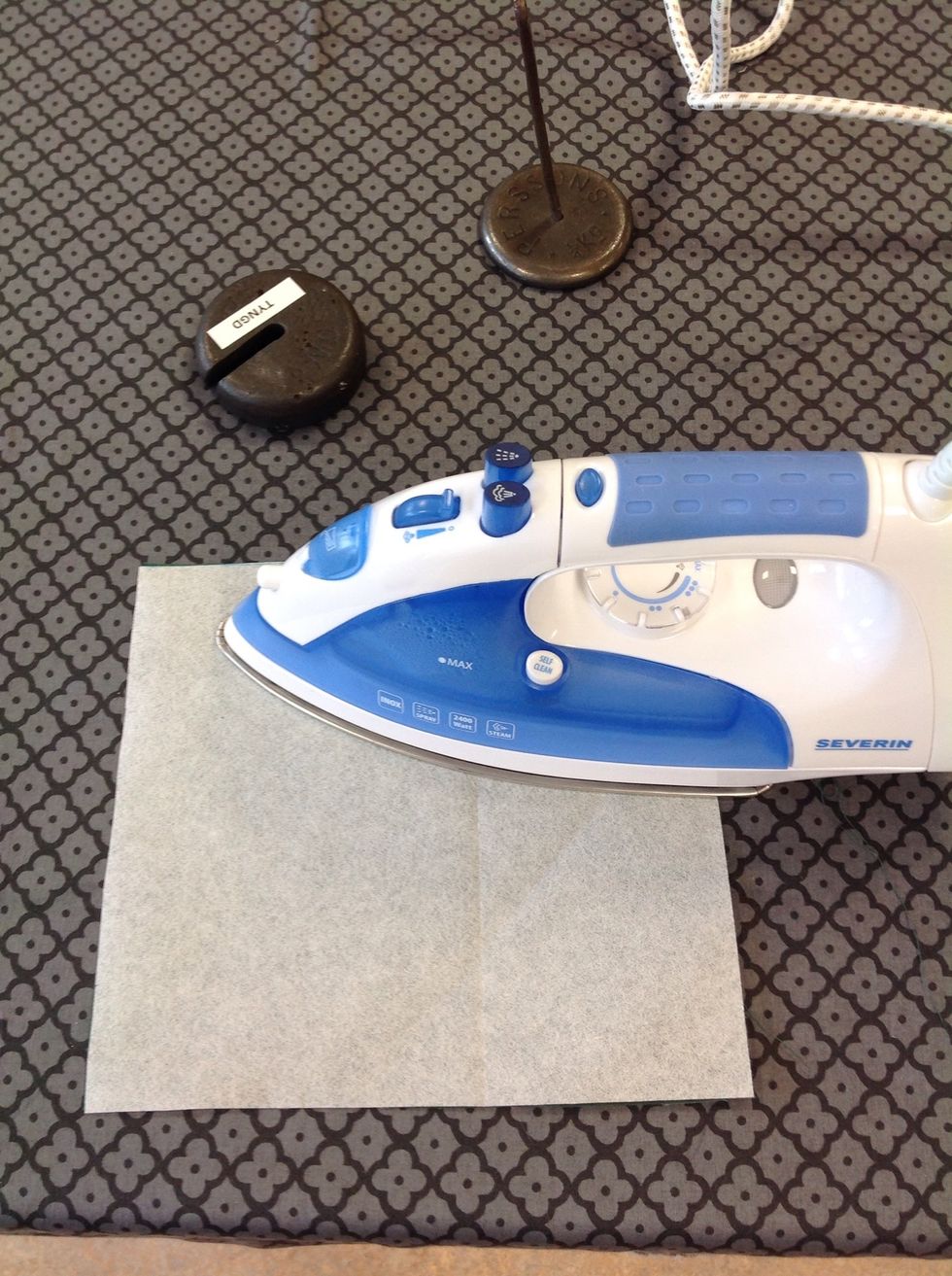 Stryk fast vliselinebiten. H\u00e5ll still strykj\u00e4rnet ca 8 sekunder p\u00e5 varje st\u00e4lle. G\u00f6r s\u00e5 \u00f6ver hela tygbiten.