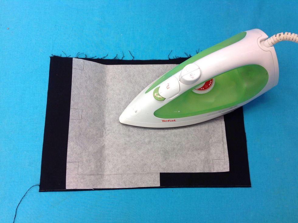 Stryk fast vliselinet p\u00e5 avigsidan (baksidan) av ditt tyg.