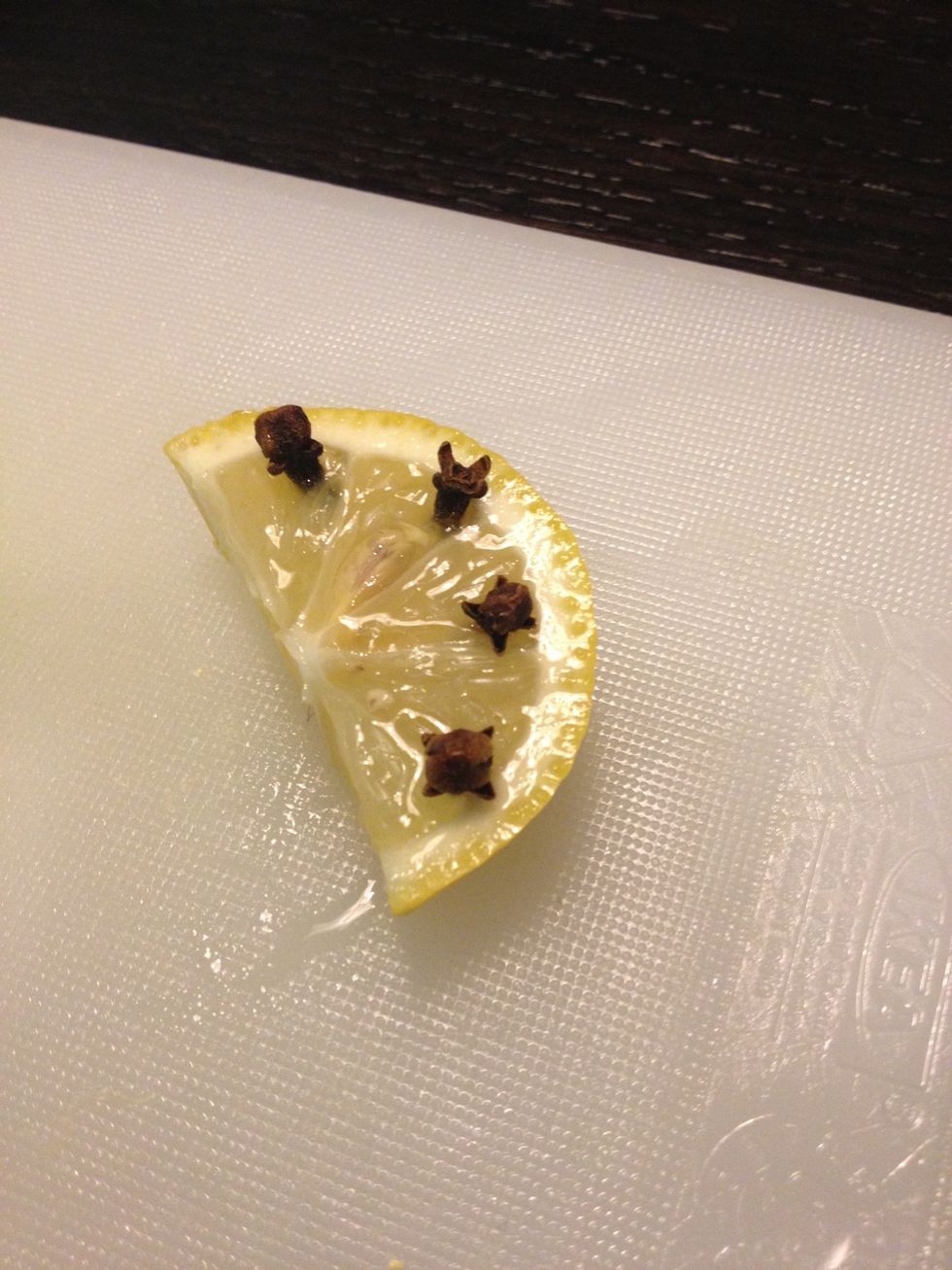 Stud the lemon slice with the cloves.