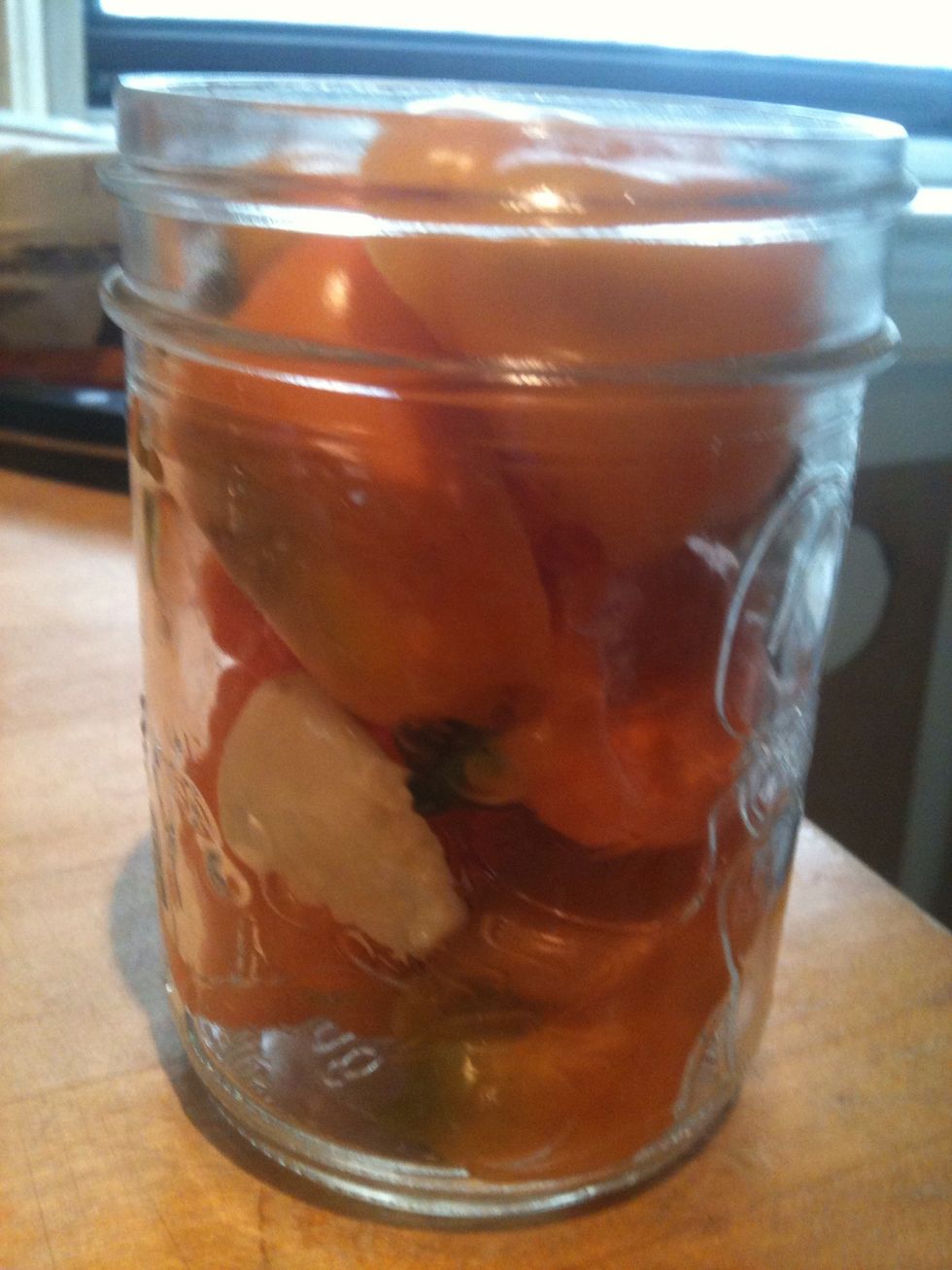 Stuff peppers and garlic in mason jar. Use whatever peppers you like, I used habanero, jalape\u00f1o and cayenne peppers. I used separate jars for different peppers, to get a variety of heat.