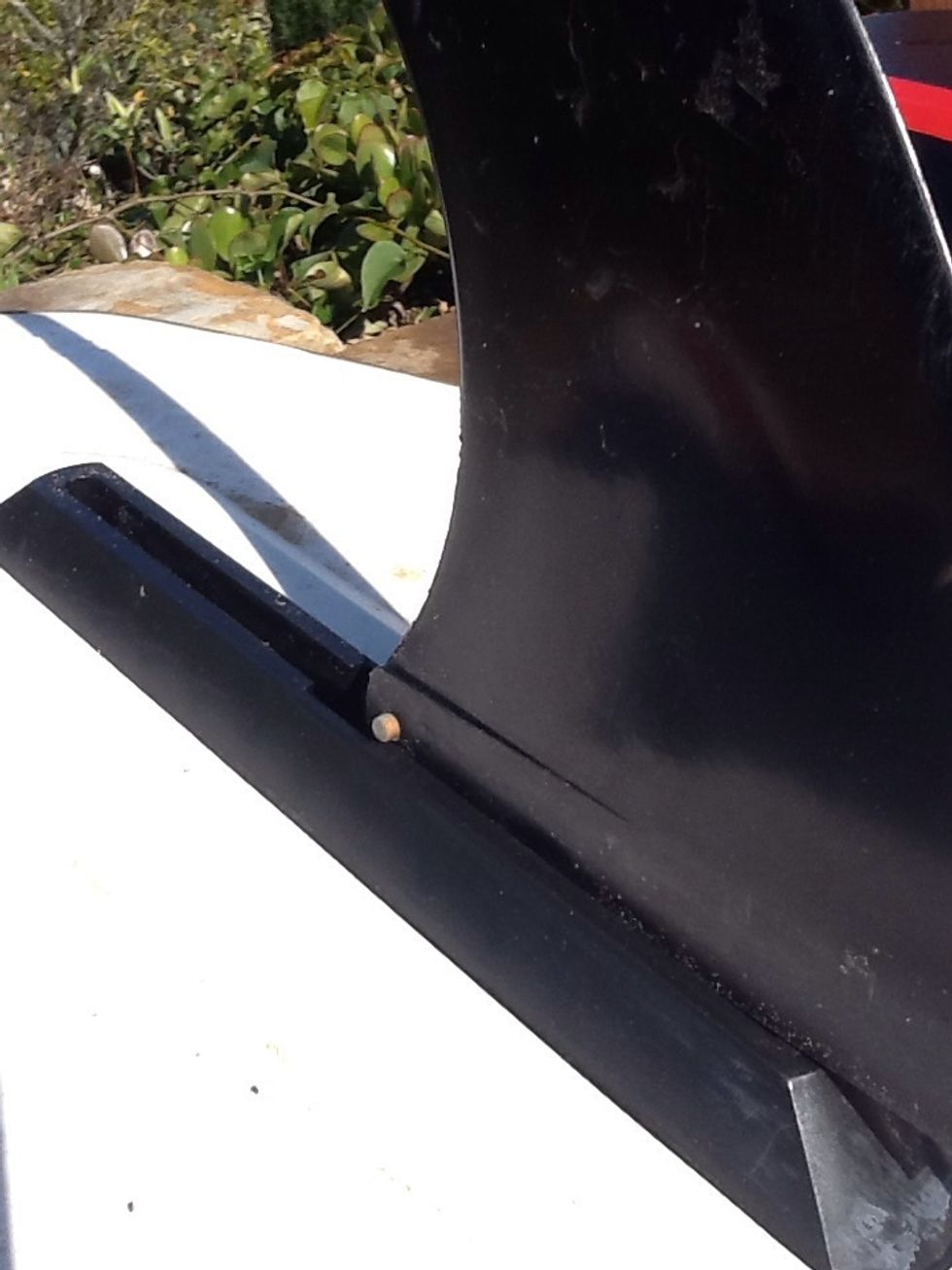 Surfer fin - Step 1 - towards the back of the fin is a brass knob on either side. Drop this into the opening on the long groove. You may have to push the knob on one side to center it on the fin.